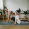 Why you should consider a Mommy Makeover Mother doing on yoga mat with little daughter at home.