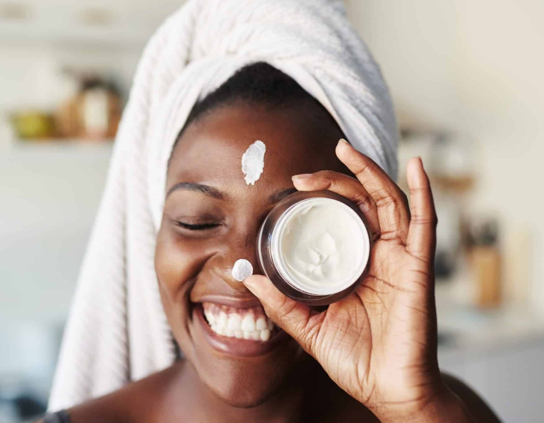 Shot of a beautiful young woman holding up a face cream product