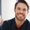 Do I need Botox or dermal fillers? Portrait of a young businessman sitting in an office with his colleagues in the background