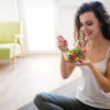 5 tips to protect your cosmetic surgery investment Woman eating healthy salad after working out at home