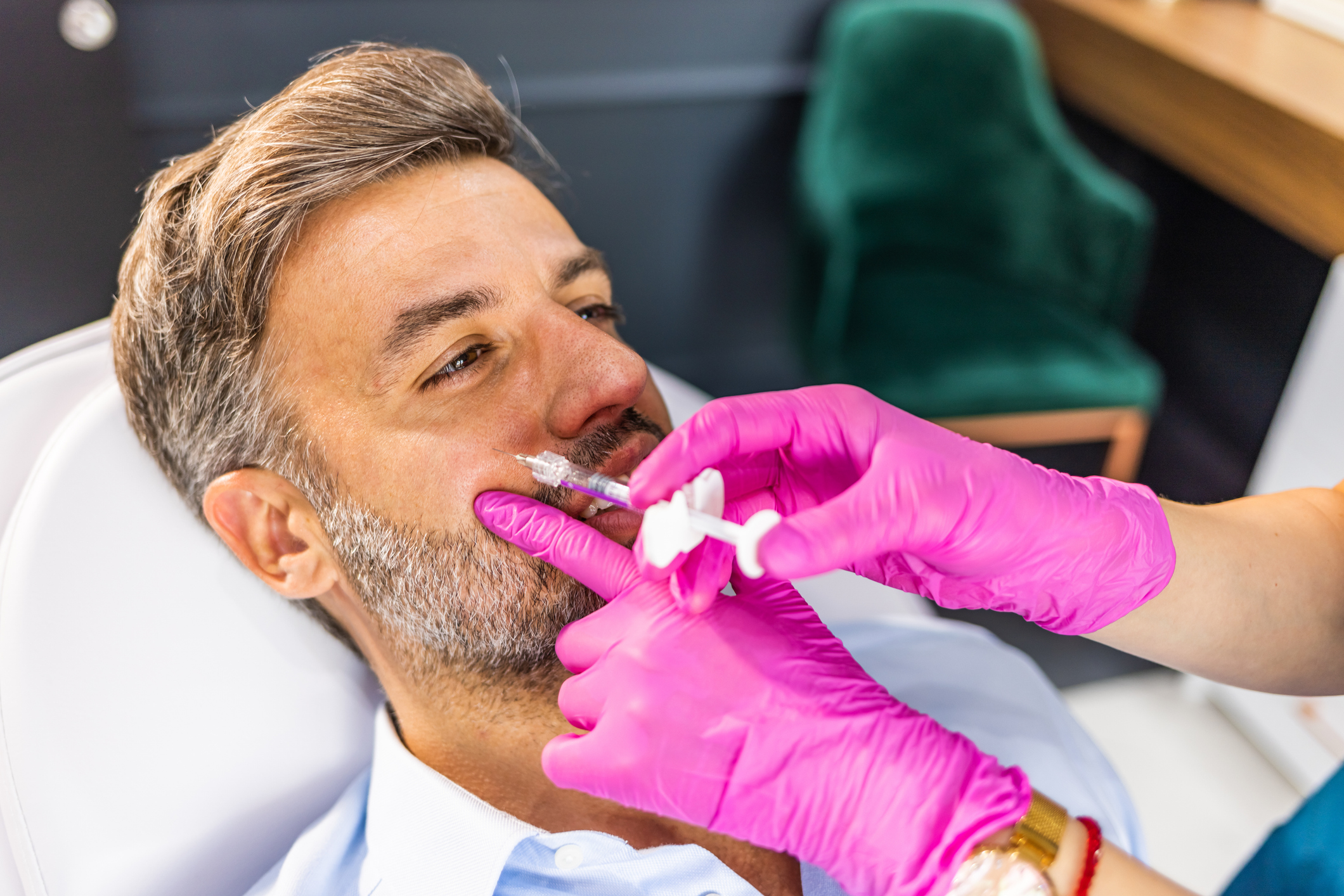 Expert beautician is filling male wrinkles with botulinum toxin injections or hyaluronic acid fillers.